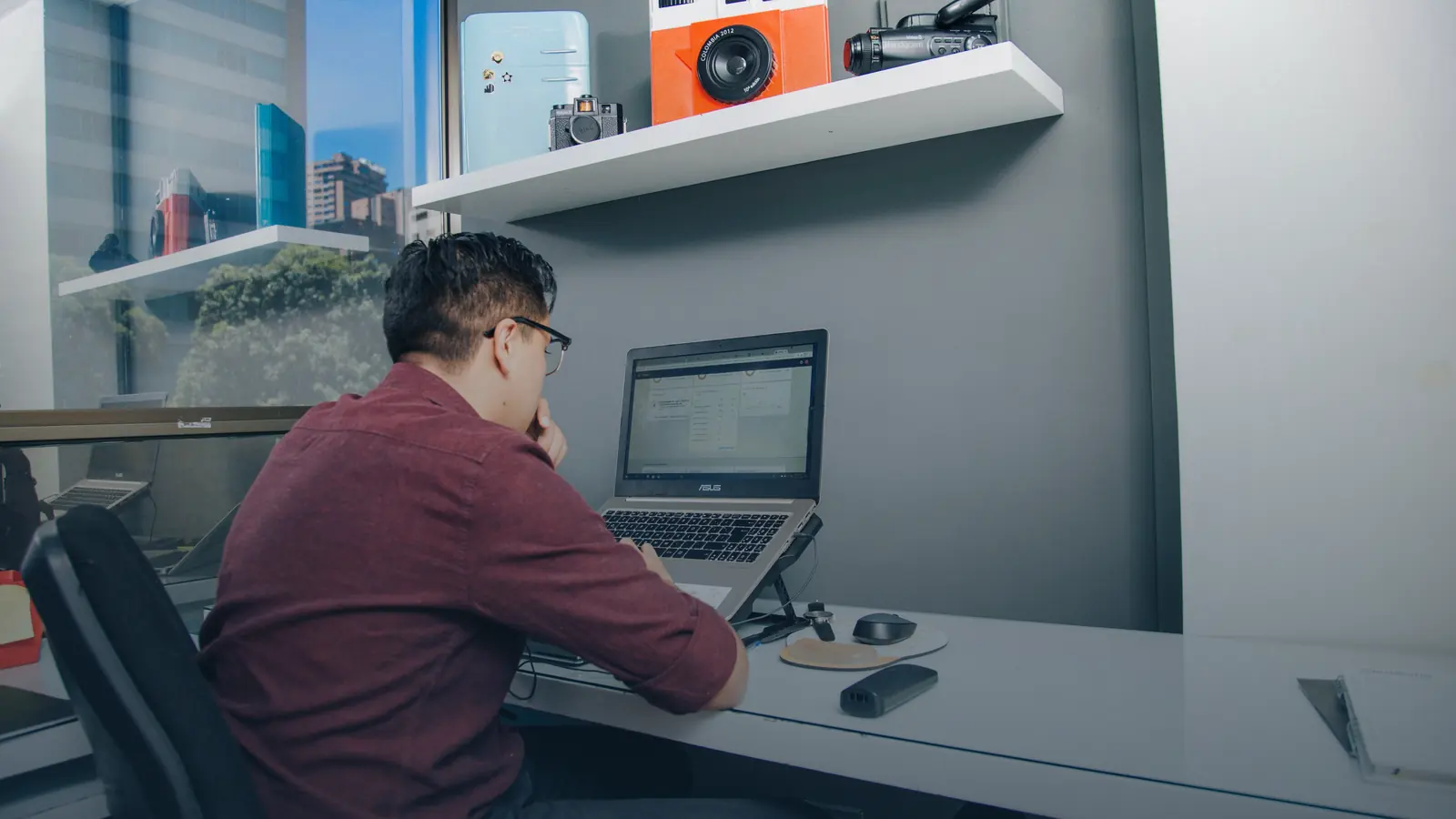 Personne de dos travaillant sur un ordinateur portable à un bureau